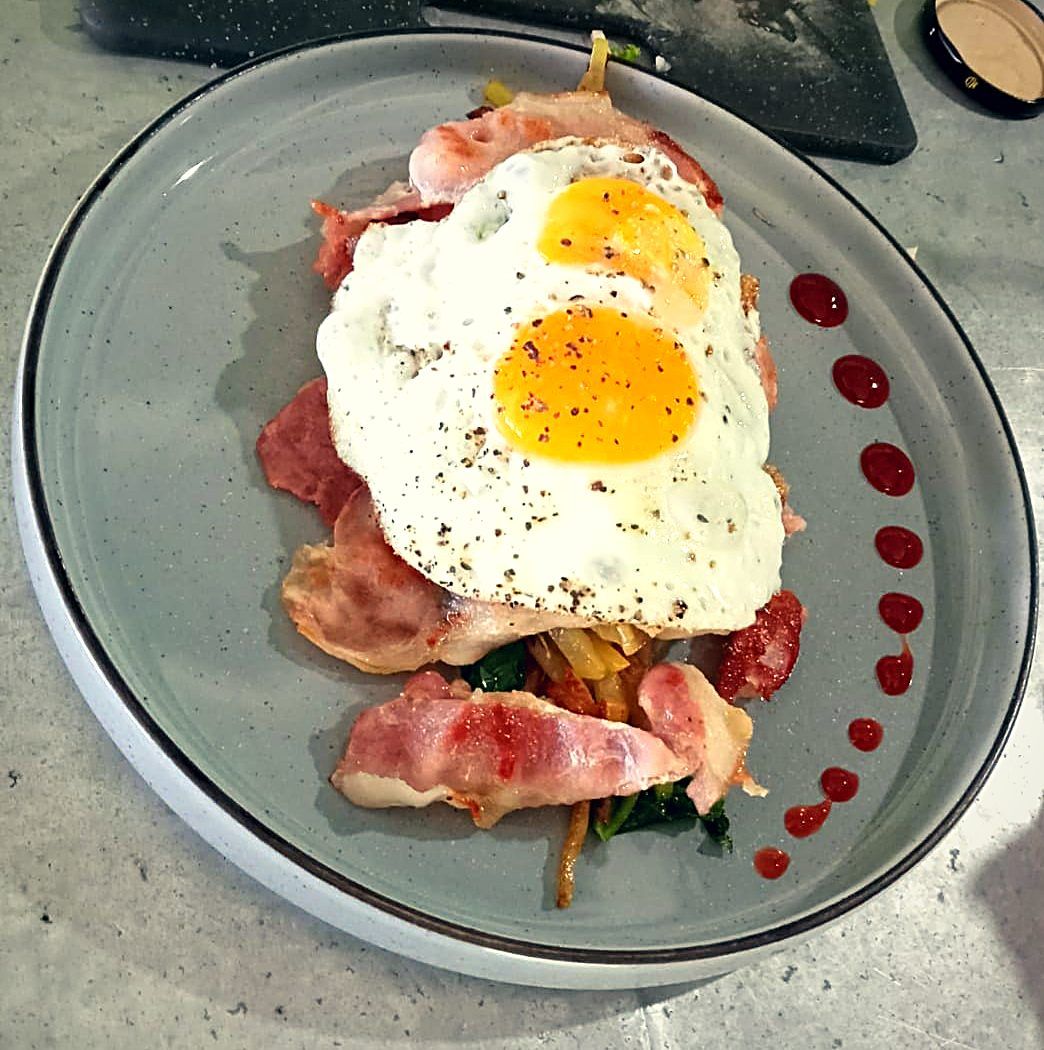 Bacon and eggs plated with greens
